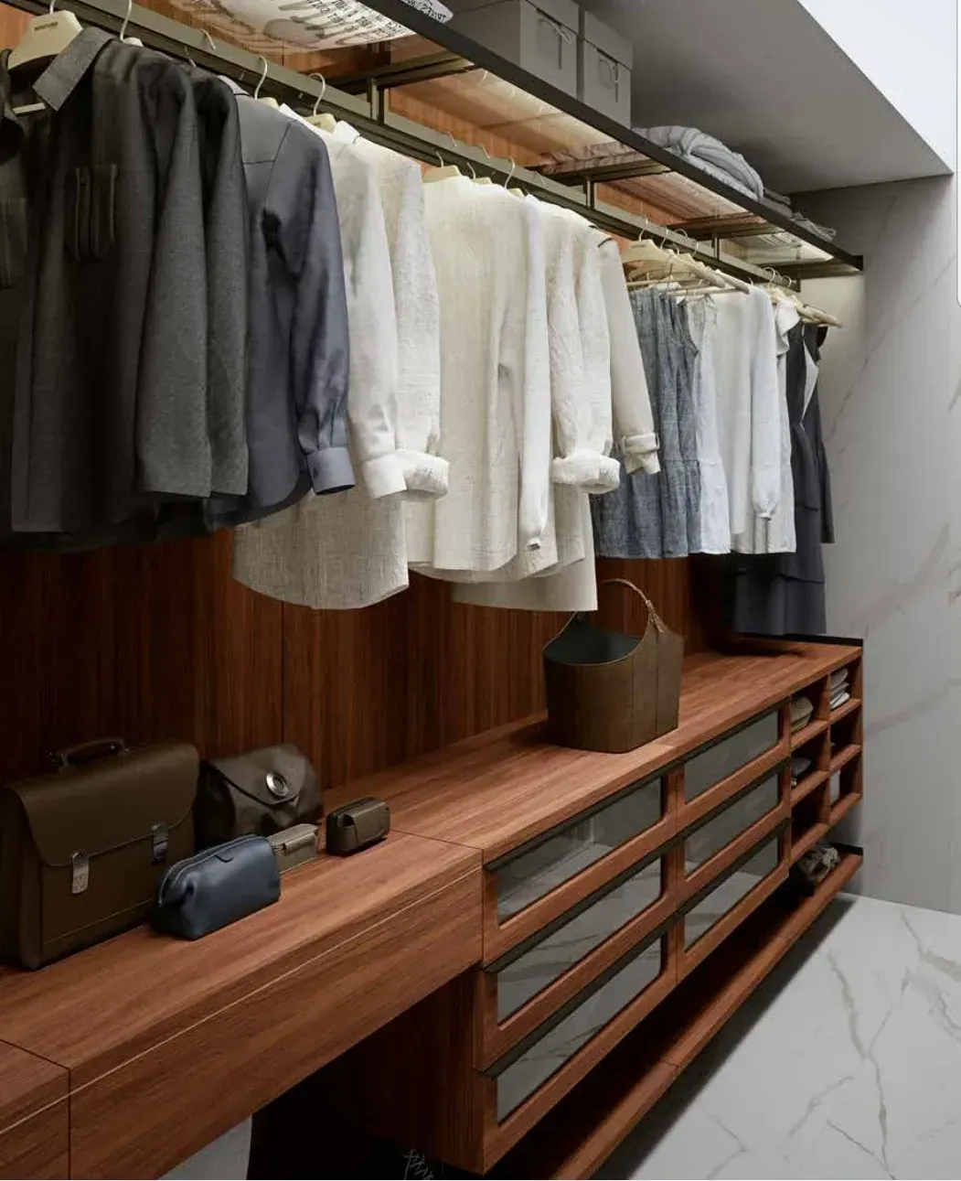 Un vestidor con ropa colgada en estantes y cajones.