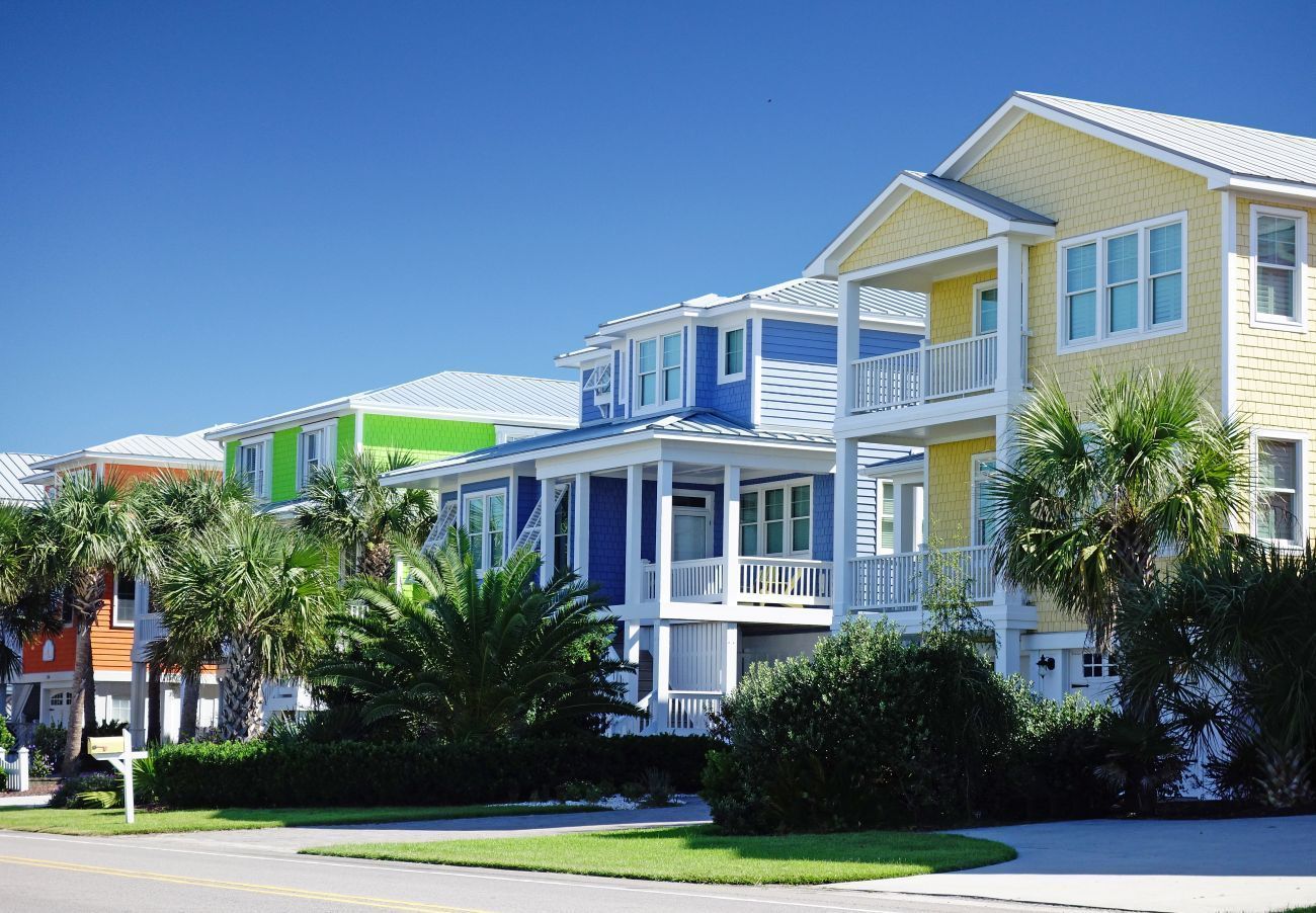 Colorful beach houses with balconies against a bright blue sky.