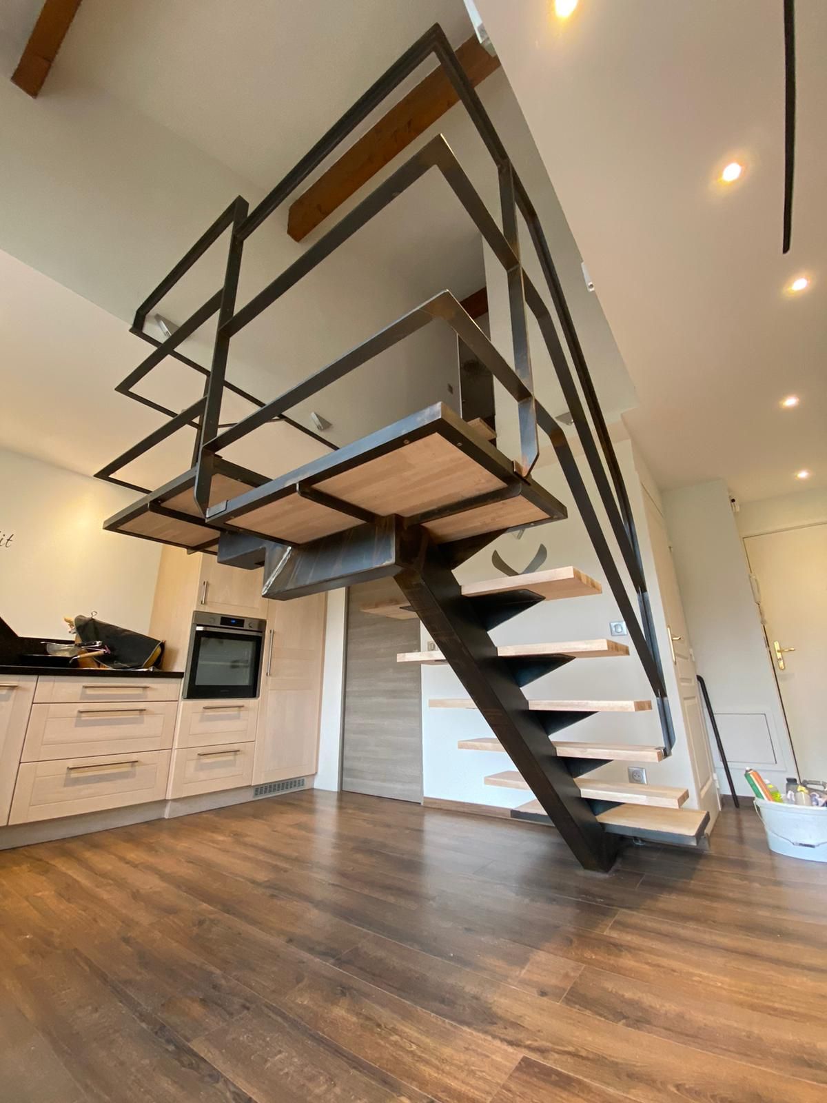 Dessous d'un escalier métallique avec des marches en bois
