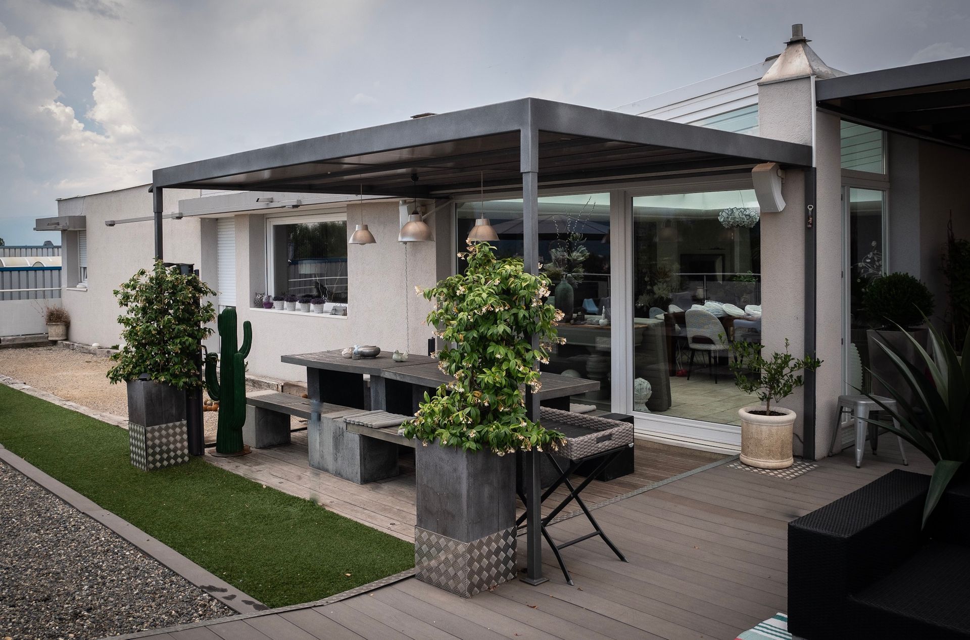 Table et banc en bois sur une terrasse sous une pergola en acier