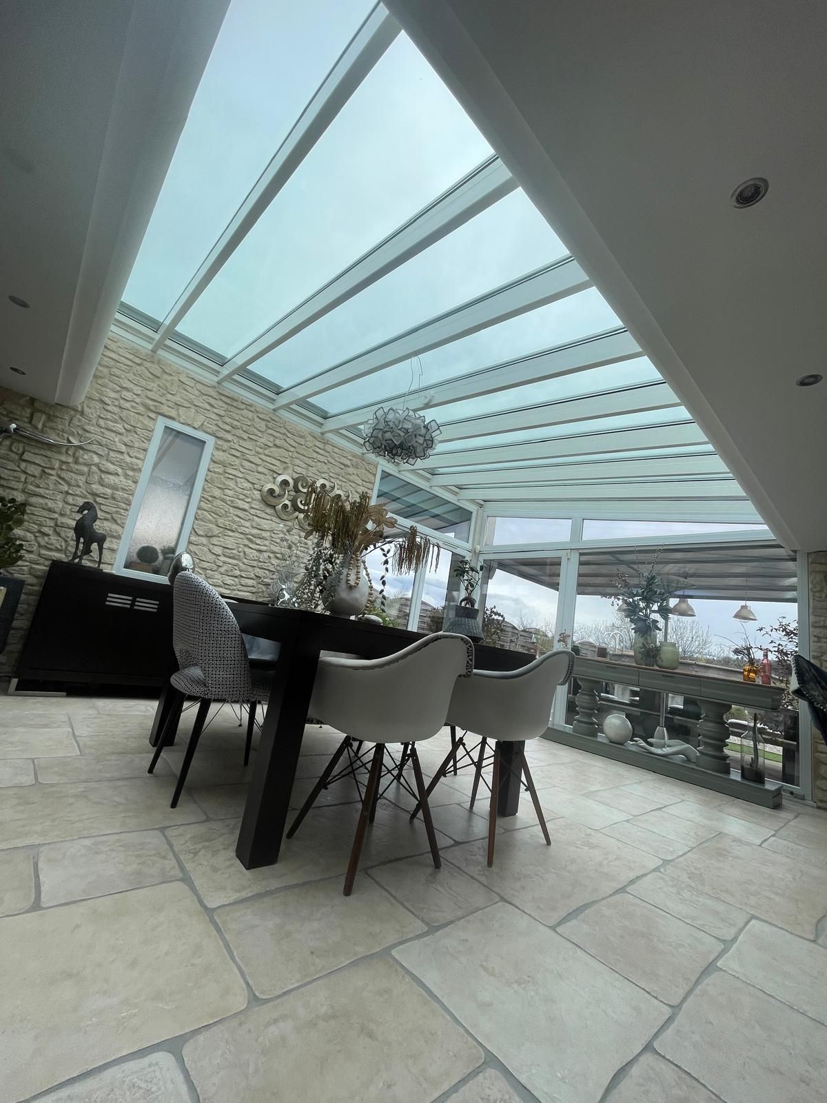 Vue intérieure d'une véranda avec salon de jardin