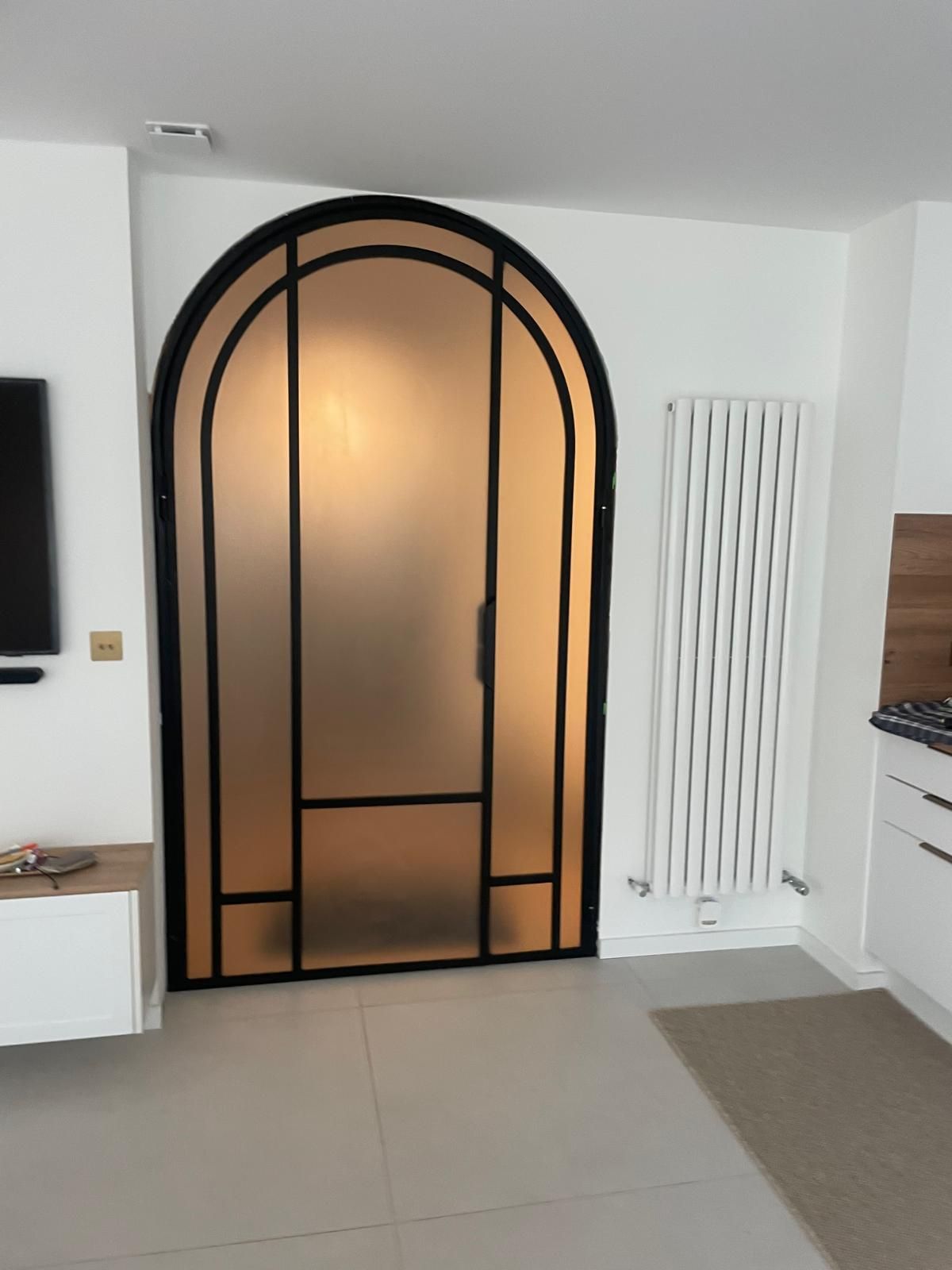 Porte verrière cintrée noire avec panneaux de verre dépoli