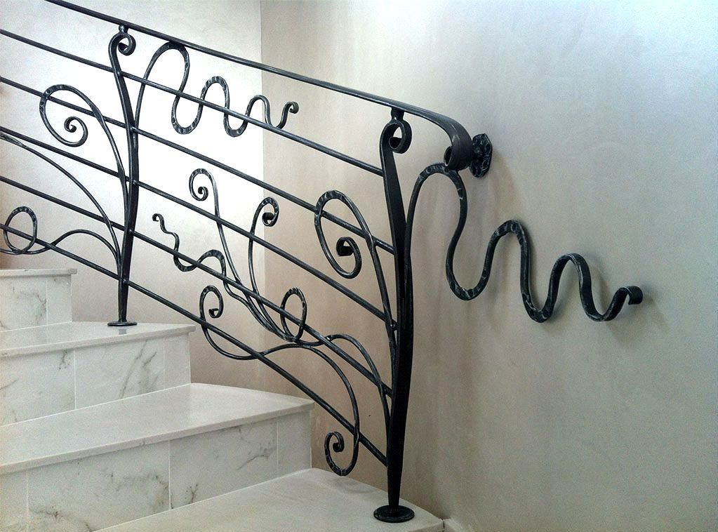 Garde corps d'un escalier en fer forgé en forme de vagues et spirales