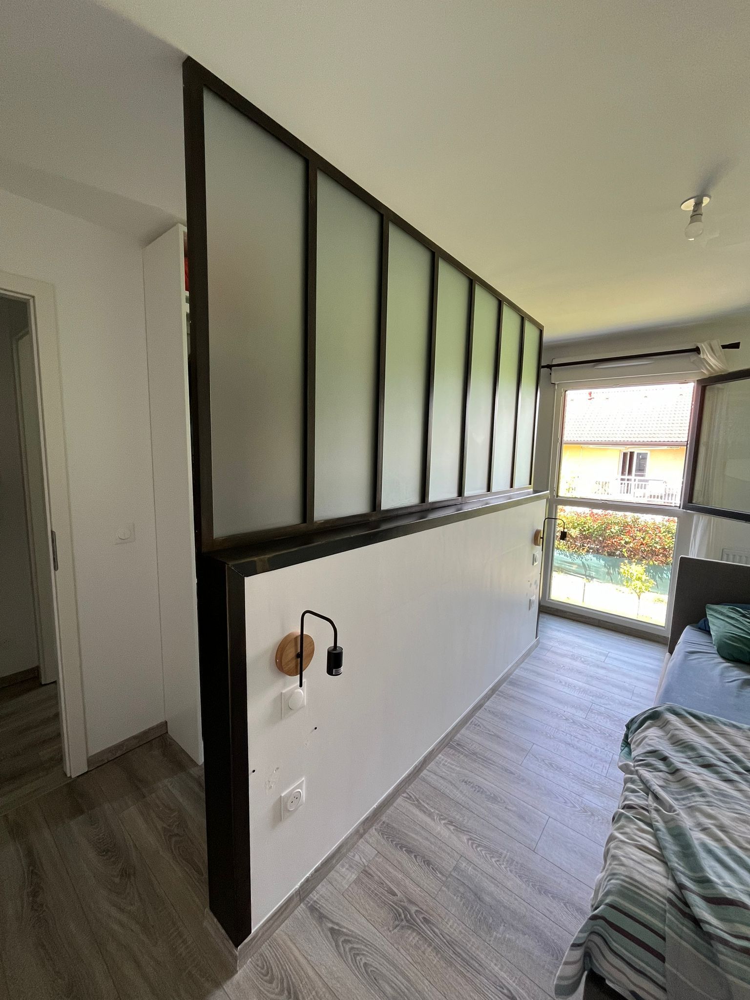 Verrière en verre dépoli, mur blanc et cadre en bois foncé