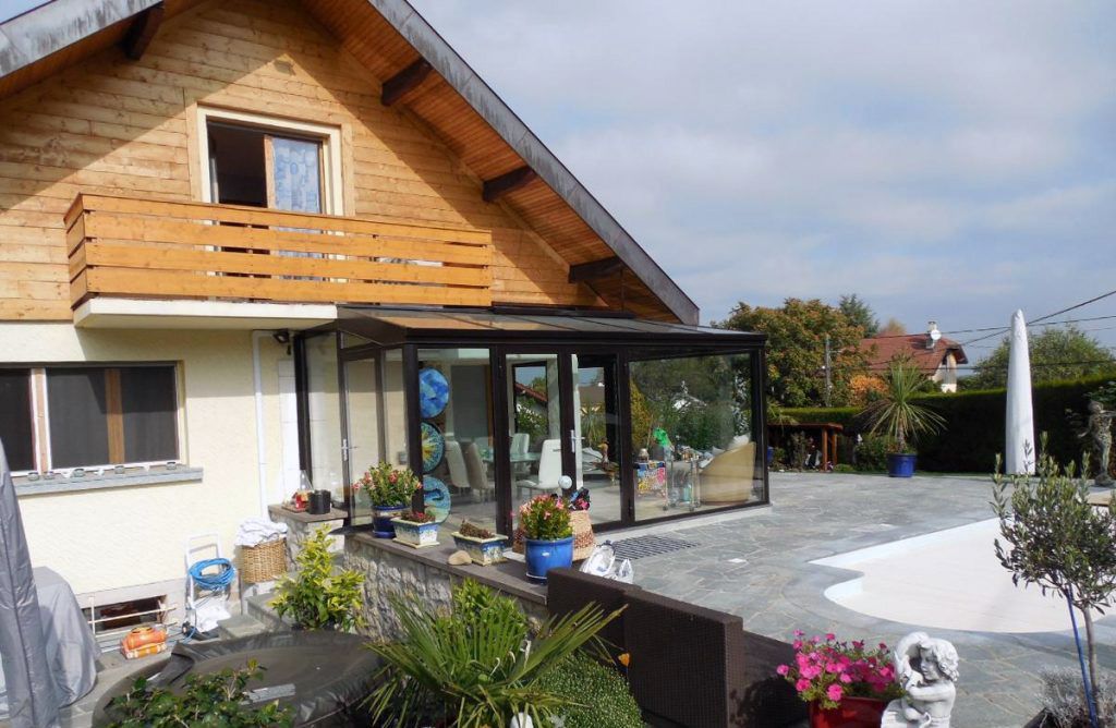Véranda vitrée accolé à une maison aux allures de chalet