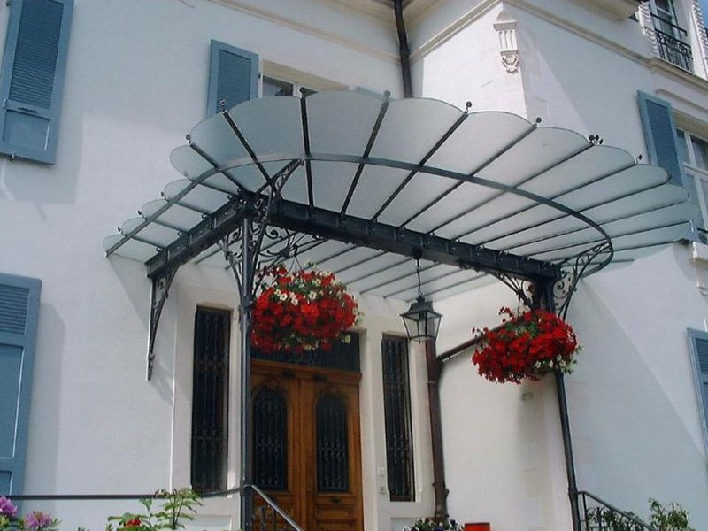 Marquise en fer forgée au dessus d'une porte d'entrée d'une habitation