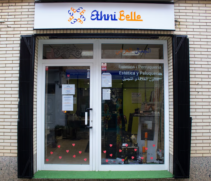 Vista frontal de la tienda Ethni Belle con puertas de cristal y fachada de ladrillo blanco y negro.