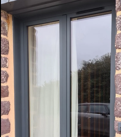 Une fenêtre en aluminium avec des rideaux