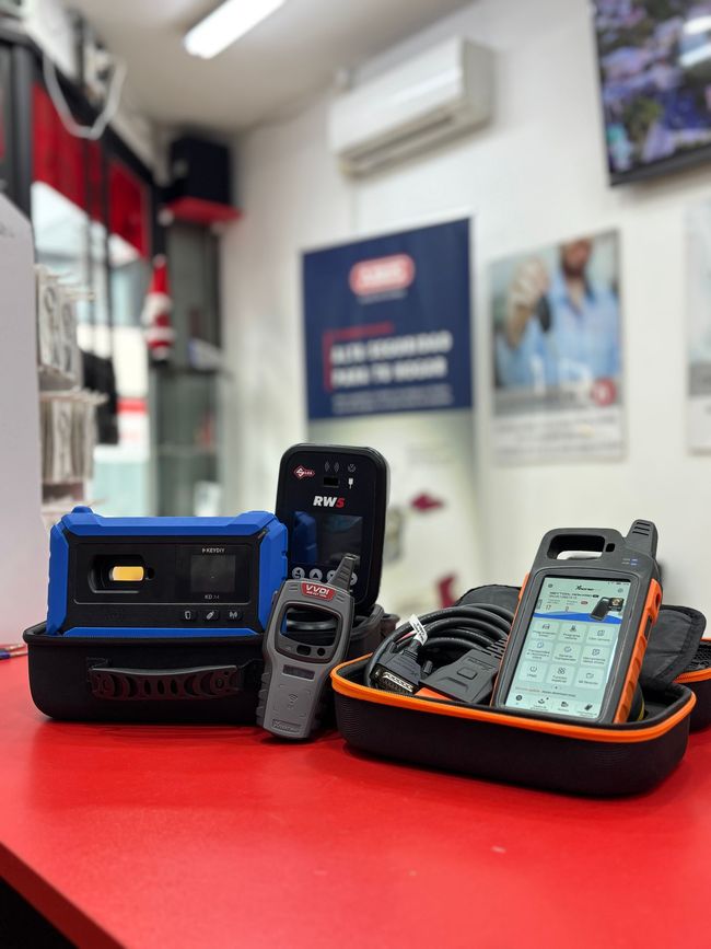Varios dispositivos electrónicos resistentes sobre un mostrador rojo; al fondo se ve el interior de una tienda.