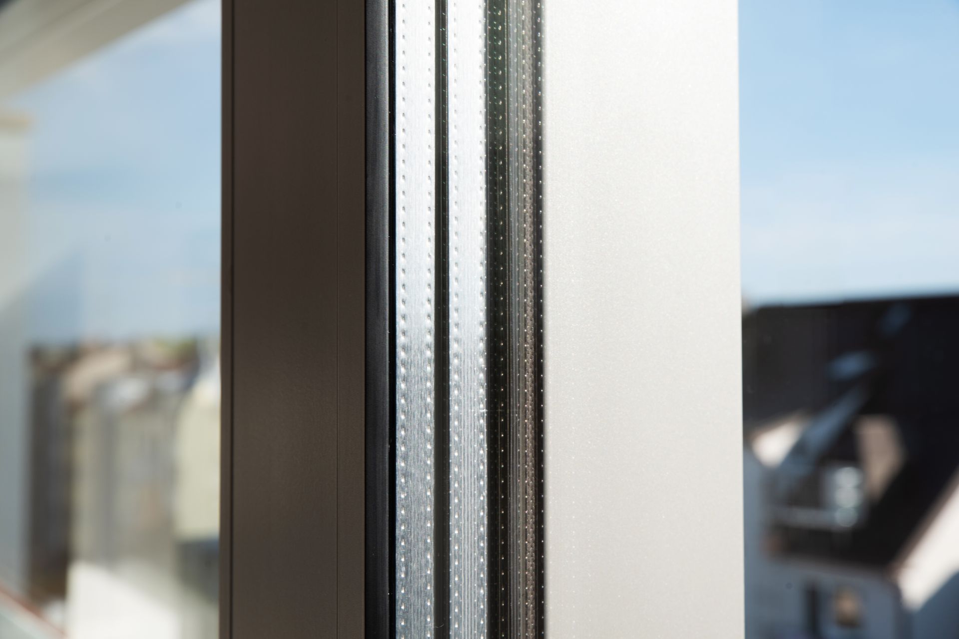 Gros plan sur un cadre de fenêtre et un panneau de verre avec une bordure verticale noire et blanche.