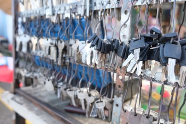 Des rangées de clés suspendues à des crochets métalliques sur un étal.