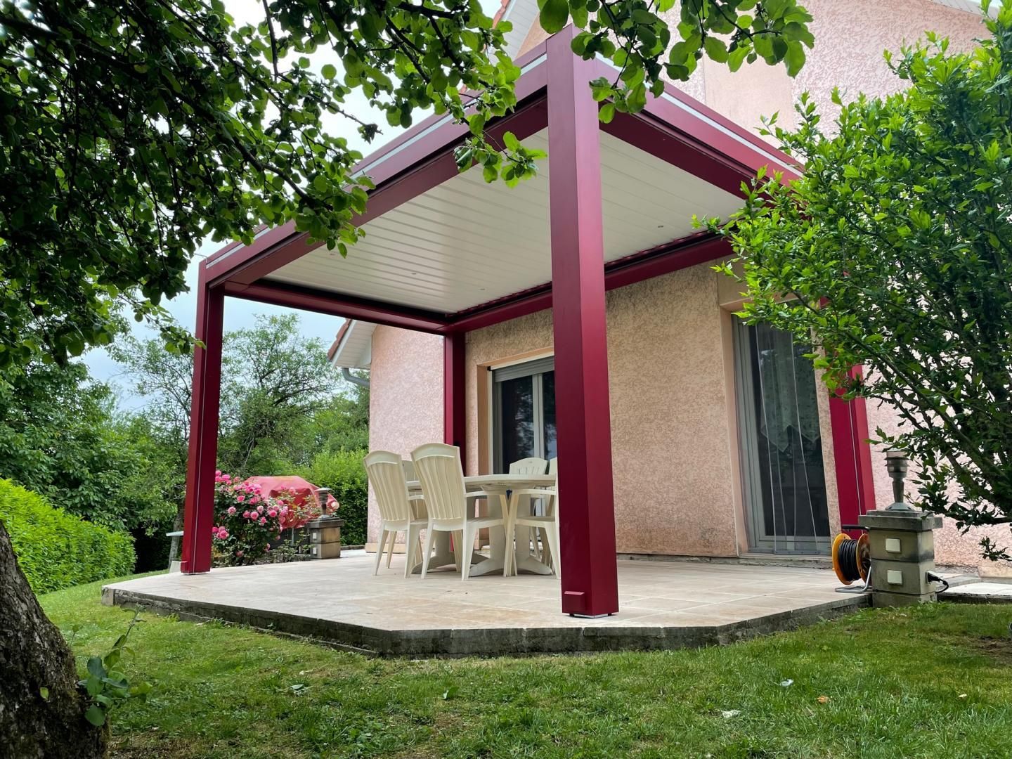 Une pergola et un salon de jardin.