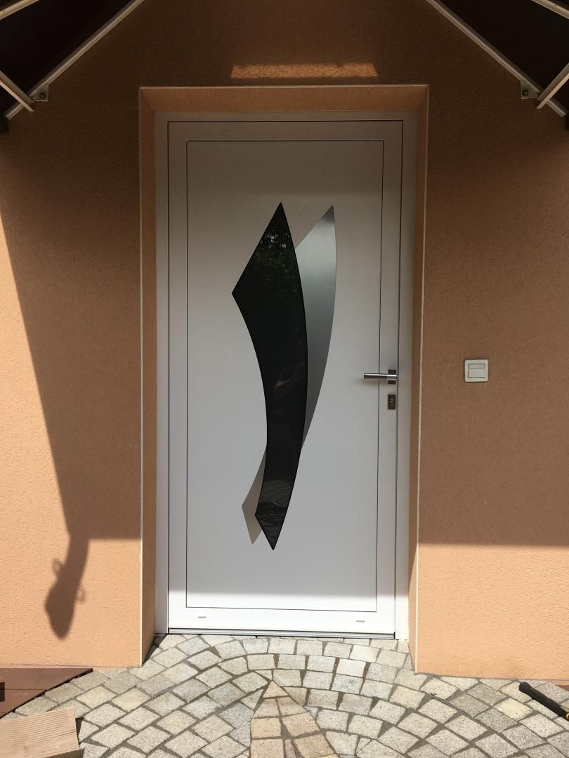 Une porte d'entrée blanche avec des décorations au milieu.