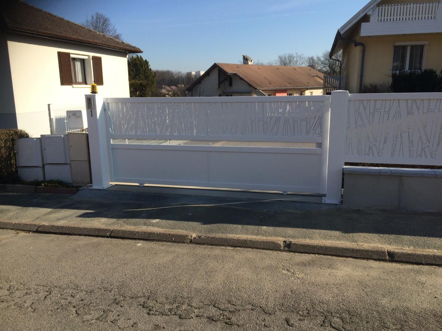 Un portail blanc et des clôtures.