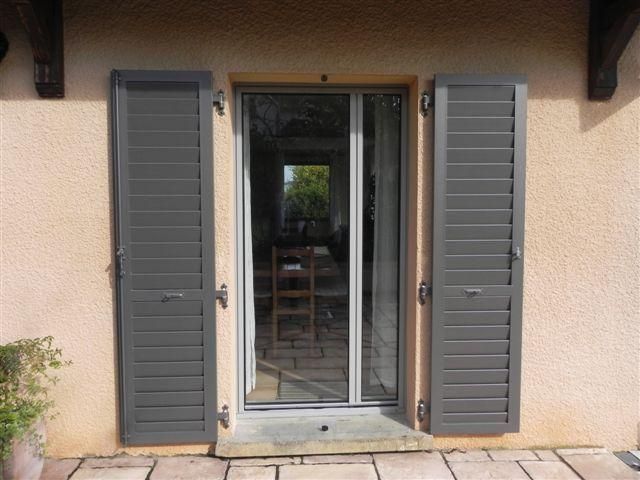 Une porte-fenêtre et des volets.