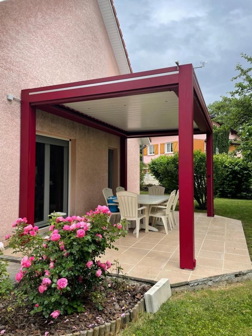 Une pergola avec des chaises de jardin.