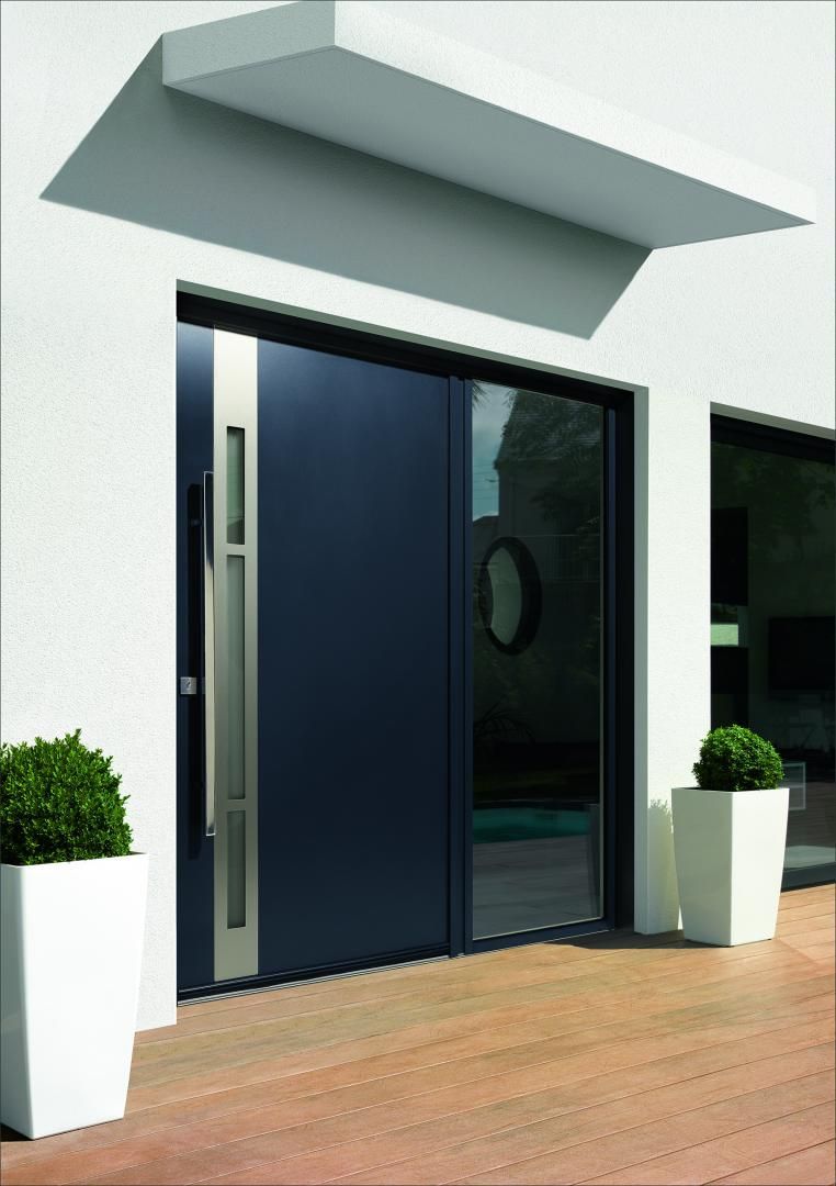 Une porte d'entrée noire avec des décorations sur la gauche.