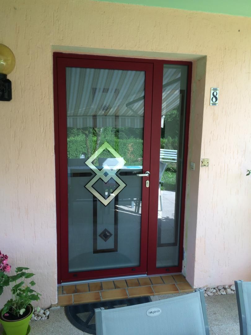 Une porte d'entrée vitrée avec des décorations.