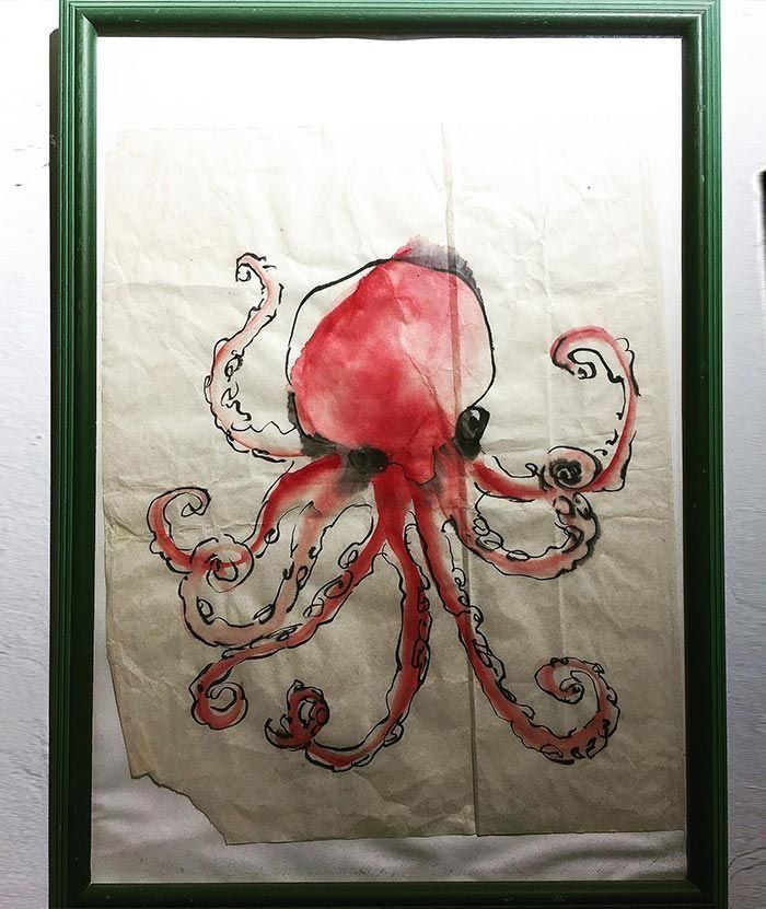 Un cuadro de un pulpo en un marco verde.