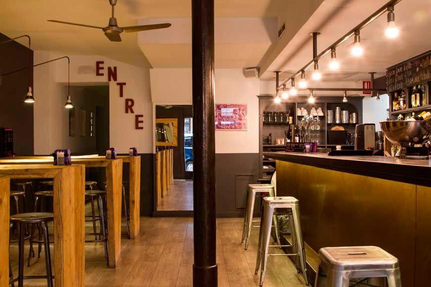 Un restaurante con mesas y taburetes y la palabra entre en la pared.