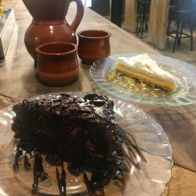 Un plato de pastel de chocolate junto a un plato de tarta de limón