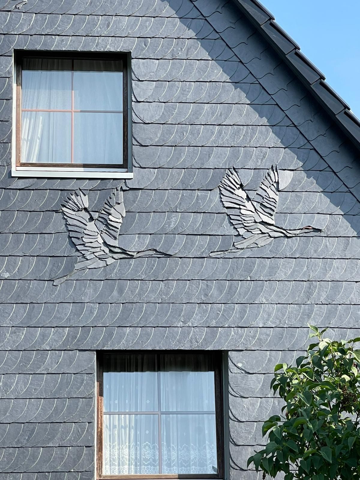 Zwei Vögel sind auf die Seite eines Hauses gemalt