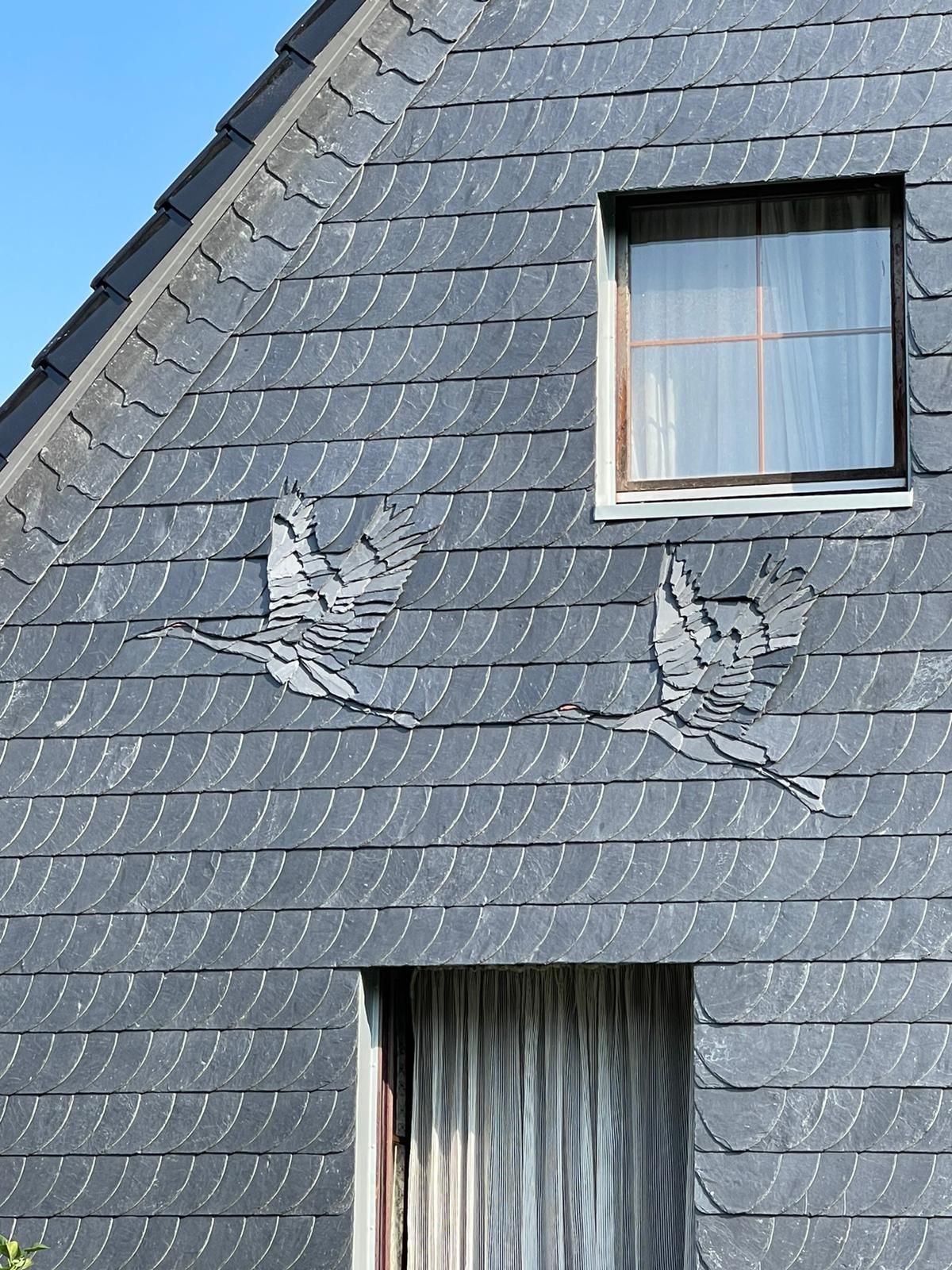 Ein Haus mit Schieferdach und Fenster