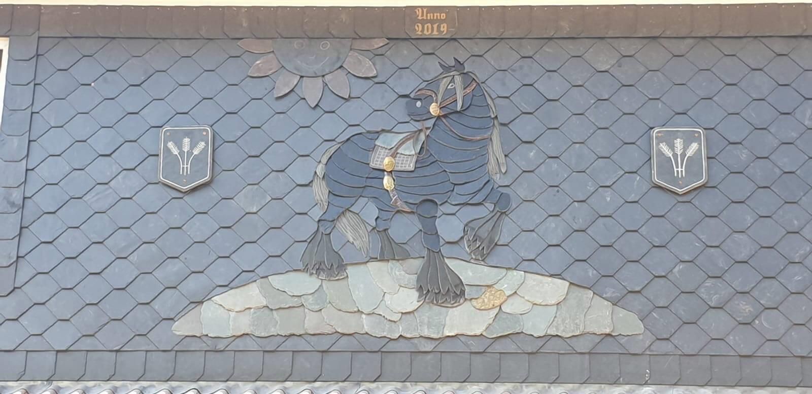 Ein Schieferdach mit einem Pferd und Schilden darauf