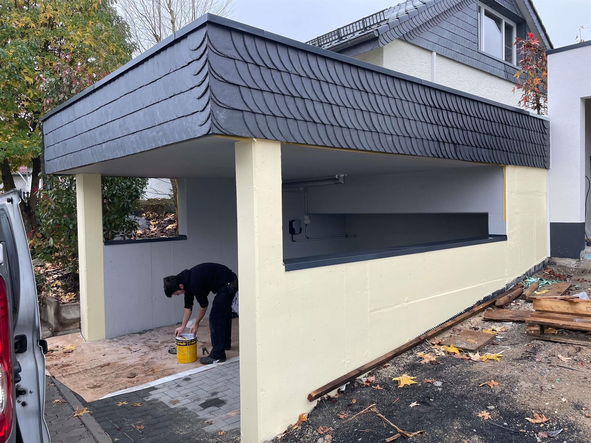 Ein Mann arbeitet an der Seite eines Gebäudes