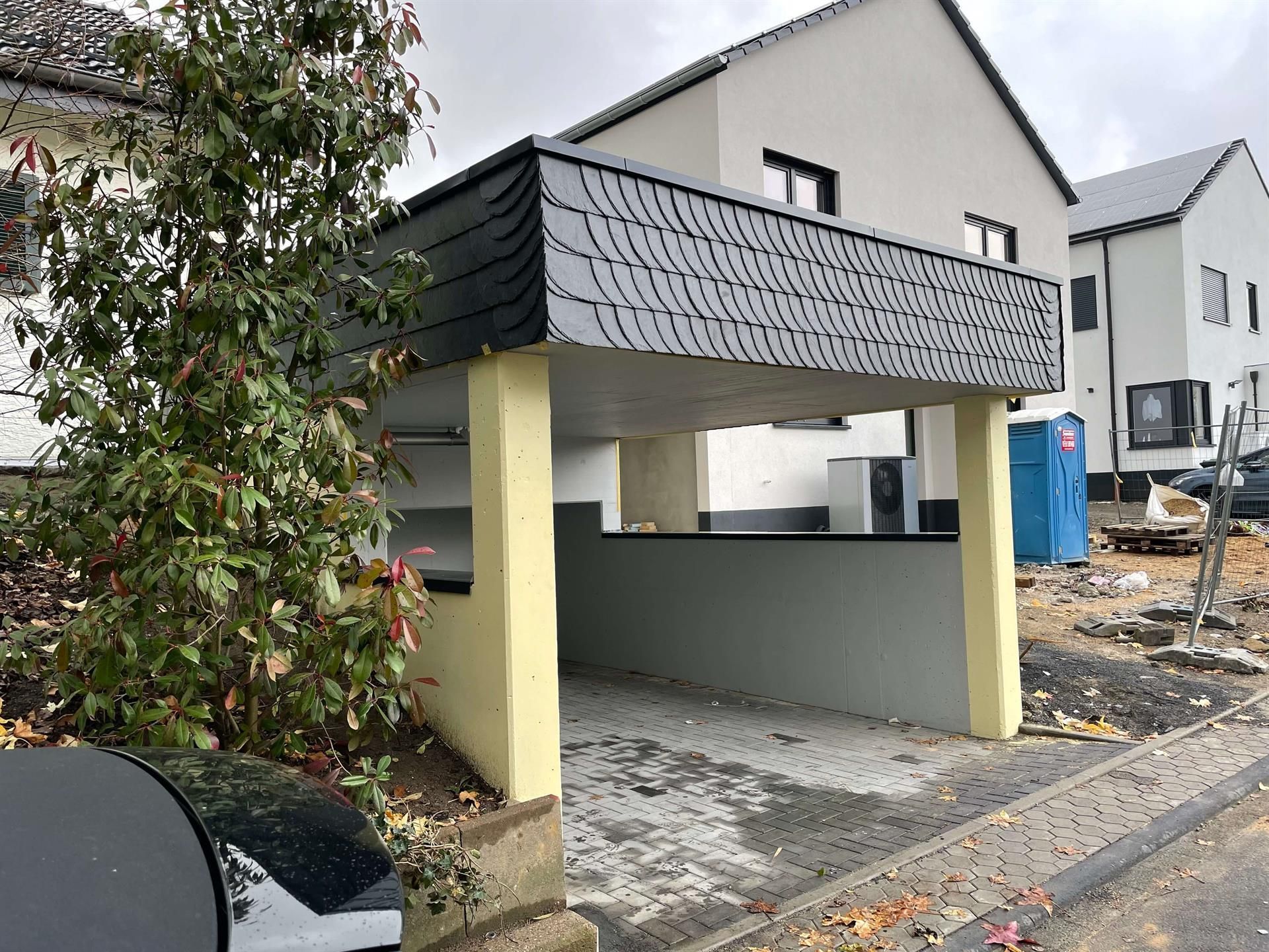 Ein Auto steht vor einem im Bau befindlichen Gebäude