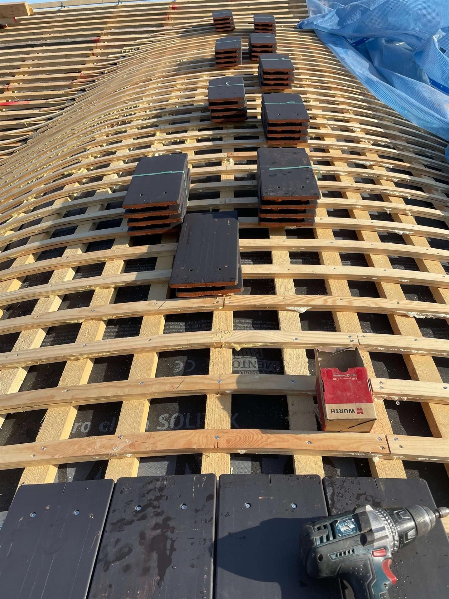 Ein Bohrer sitzt auf einem Holzdach