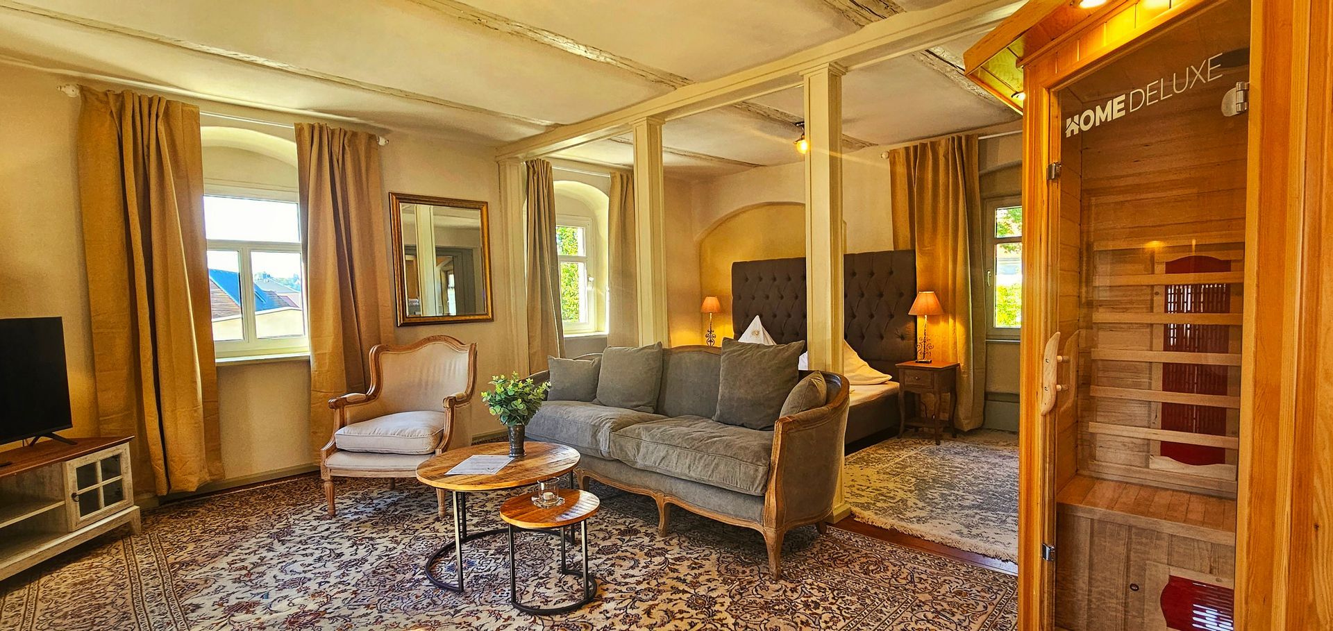 Luxuriöses Hotelzimmer mit prunkvollen Möbeln, Sofa und Sauna.