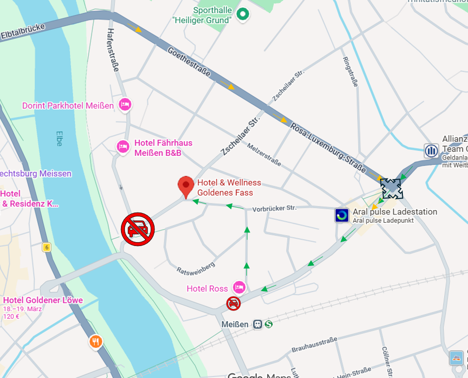 Frau beim Einchecken im Hotel, mit einer Angestellten hinter einem hölzernen Tresen mit Obst- und Getränkespender.