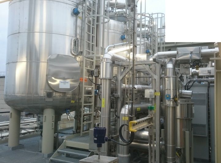 Industrielle Edelstahltanks und -rohrleitungen im Außenbereich.