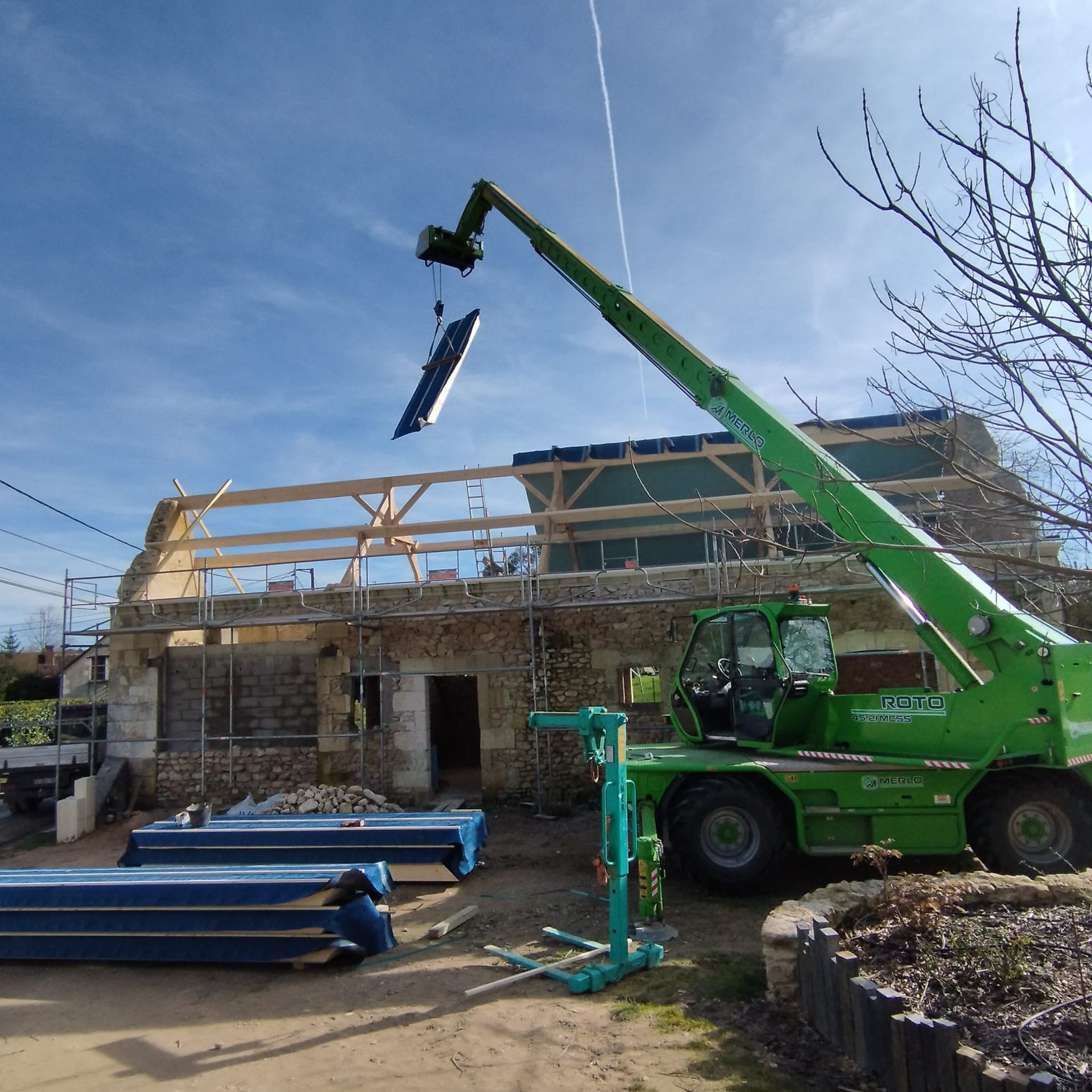 Une grue devant une maison en rénovation