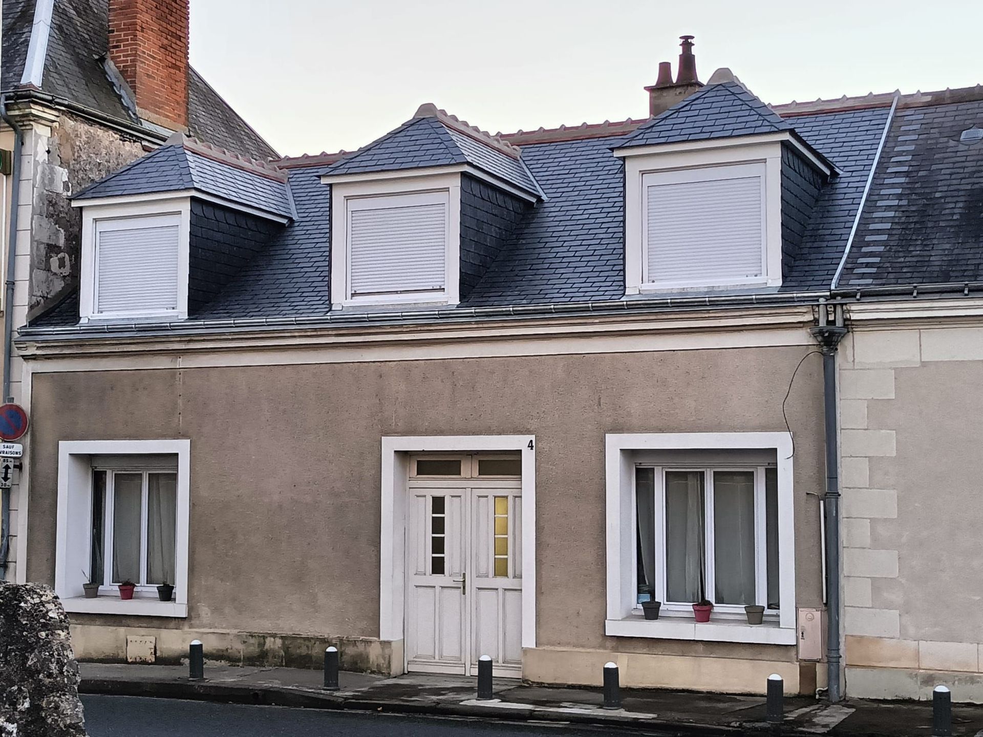 Une maison avec toiture en ardoise et fenêtres en chien-assis