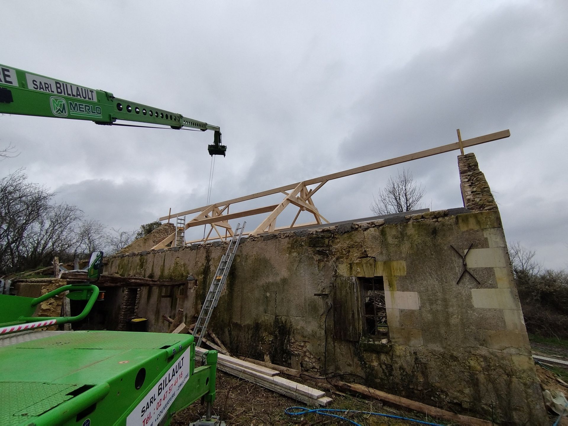 Une grue devant une maison sans toit