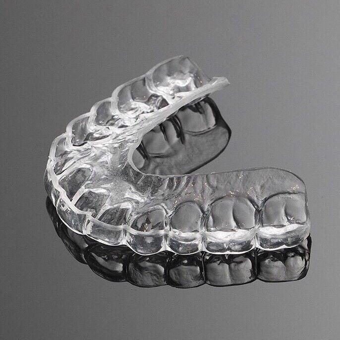 Un protector dental nocturno o retenedor de ortodoncia de plástico transparente, hecho a medida