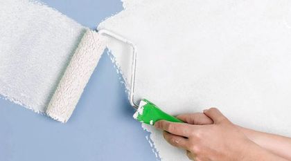 Una persona está pintando una pared con un rodillo de pintura.