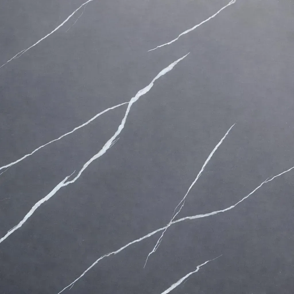 Superficie de piedra gris oscuro con vetas blancas sutiles, finas e irregulares que recorren su textura.