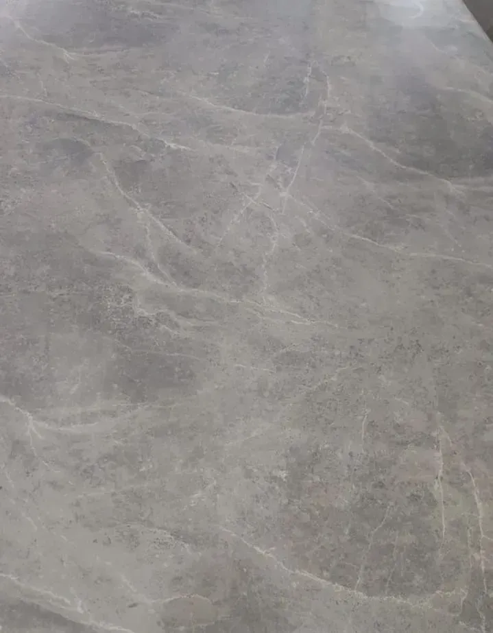 Vista de cerca de una superficie de piedra lisa y gris con vetas sutiles de color más claro.