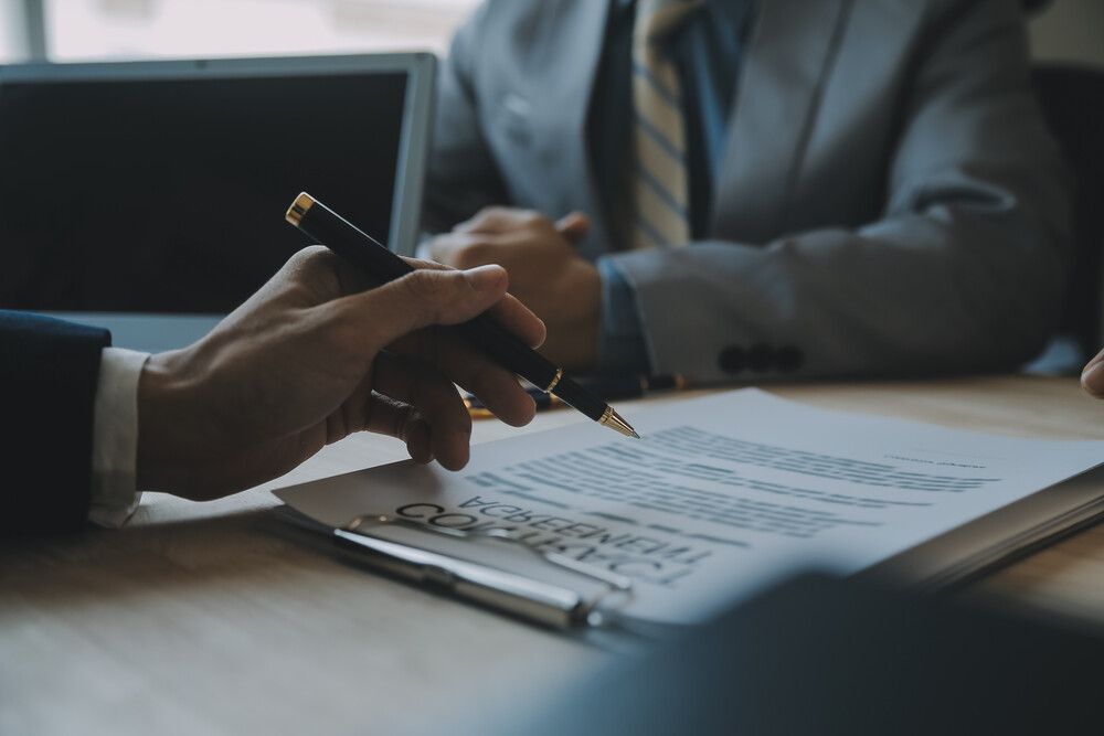 Un hombre sostiene un bolígrafo sobre un trozo de papel.