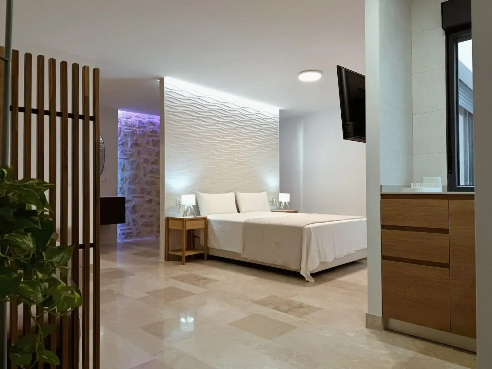 Una habitación de hotel moderna y minimalista con una cama con