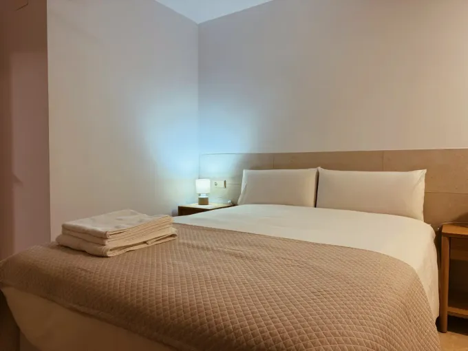 Un dormitorio moderno con una cama doble bien hecha,