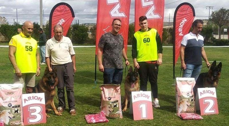 Un grupo de hombres y perros están de pie en un podio en un campo.