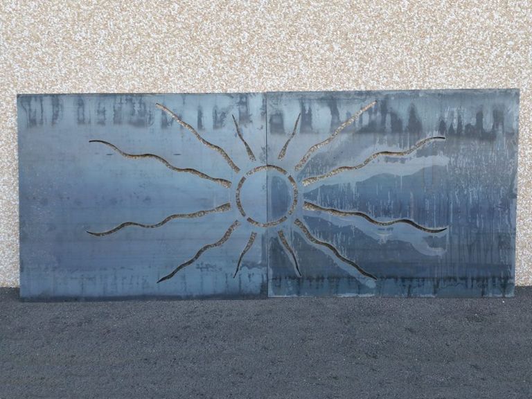 Panneau bleu vieilli orné d'un motif de soleil sur un mur en béton