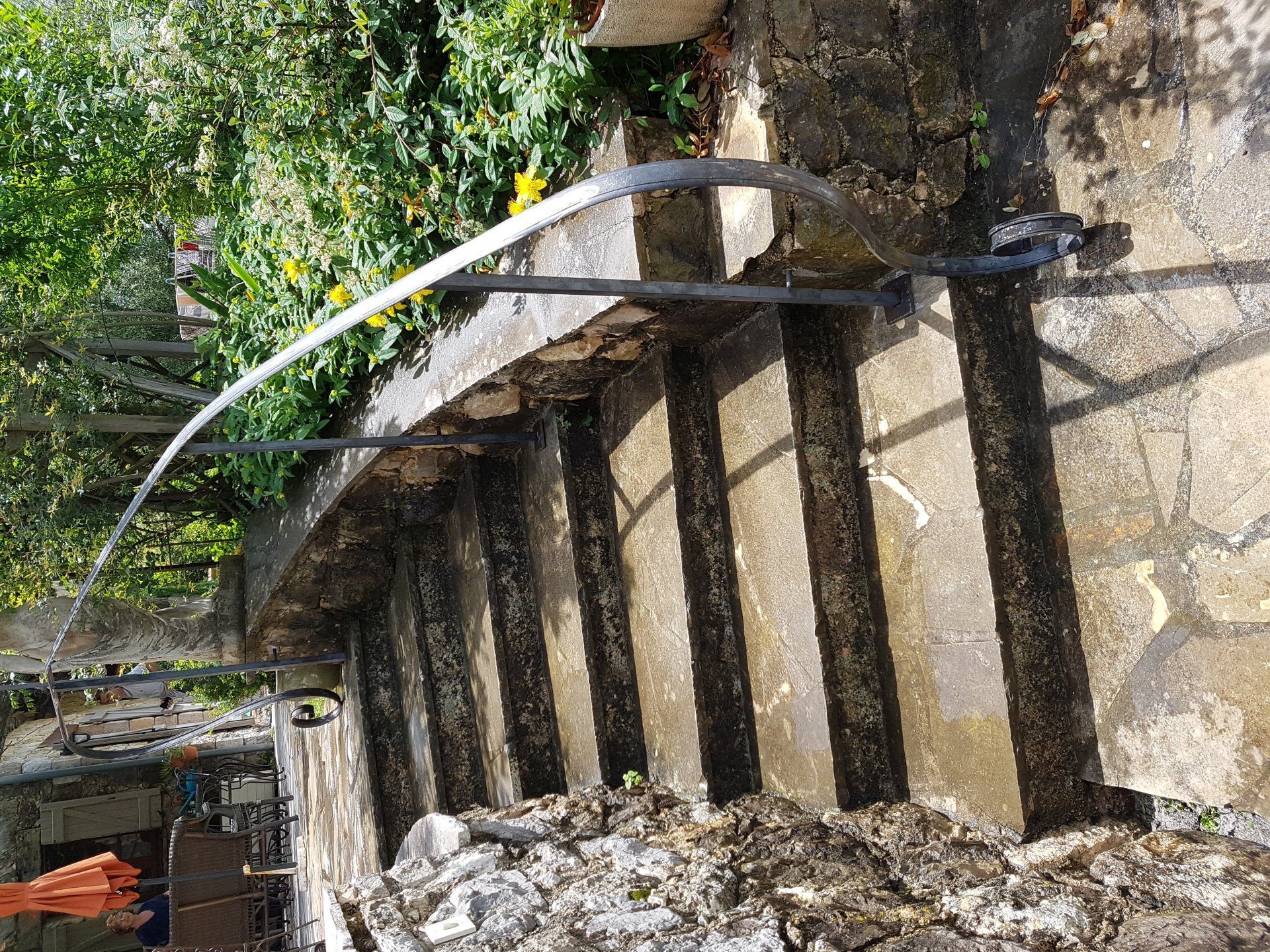 Abreuvoirs extérieurs en pierre avec eau courante sous la verdure et un mur rustique