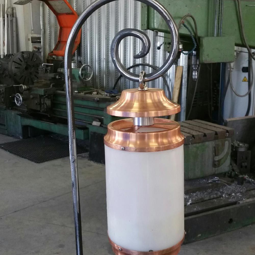 Récipient industriel en cuivre et blanc avec couvercle en métal enroulé dans un atelier