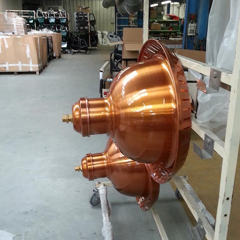 Gros composant industriel couleur cuivre sur un chariot d'usine dans un atelier