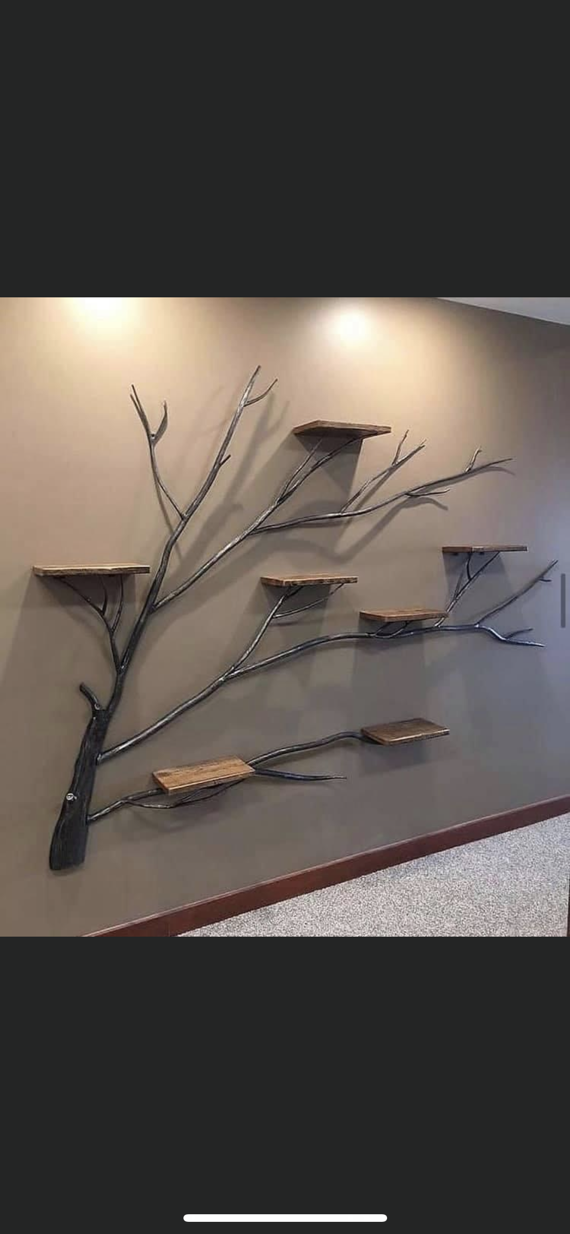 Sculpture décorative en métal représentant un arbre, fixée sur un mur beige dans un couloir